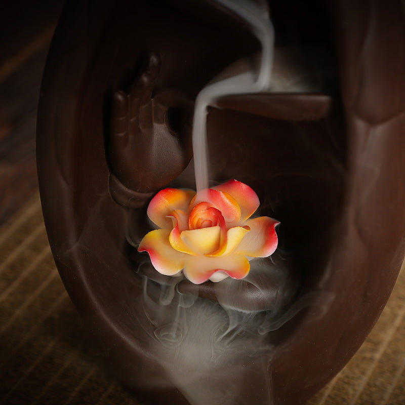 Close-up glowing lotus inside purple clay backflow incense waterfall burner