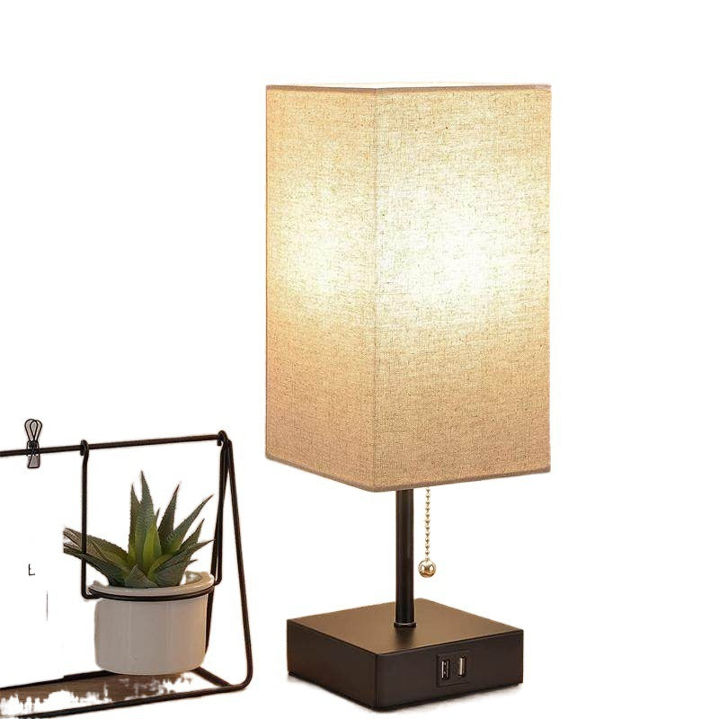 Rectangular linen shade table lamp with black base and charging ports
