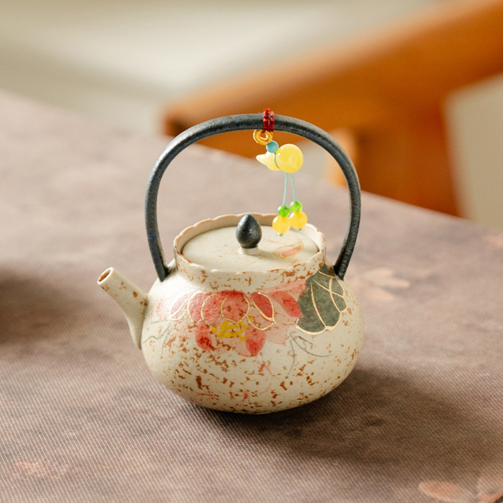 Hand-painted red koi and lotus lift-handle teapot styled on a tea mat