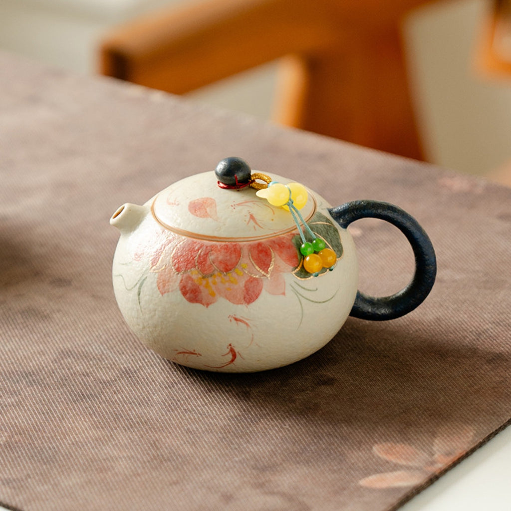 Hand-painted red koi and lotus 150ml round ceramic teapot styled on a tea mat