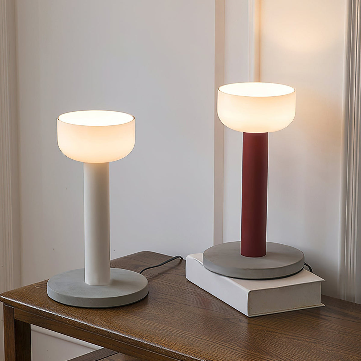 Red macaron table lamp with glowing bowl shade and marble base