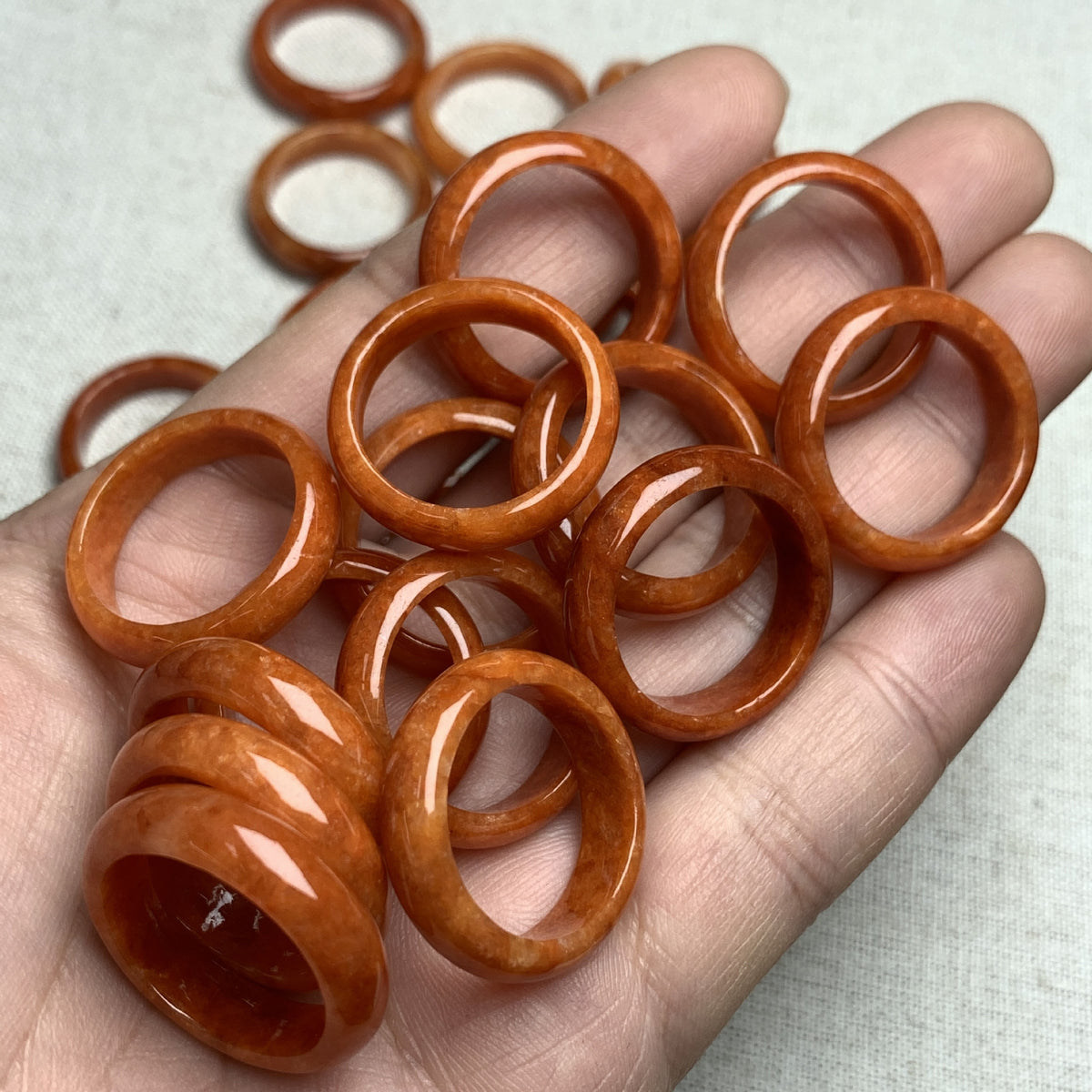Group of red orange jadeite rings showing natural individual color character