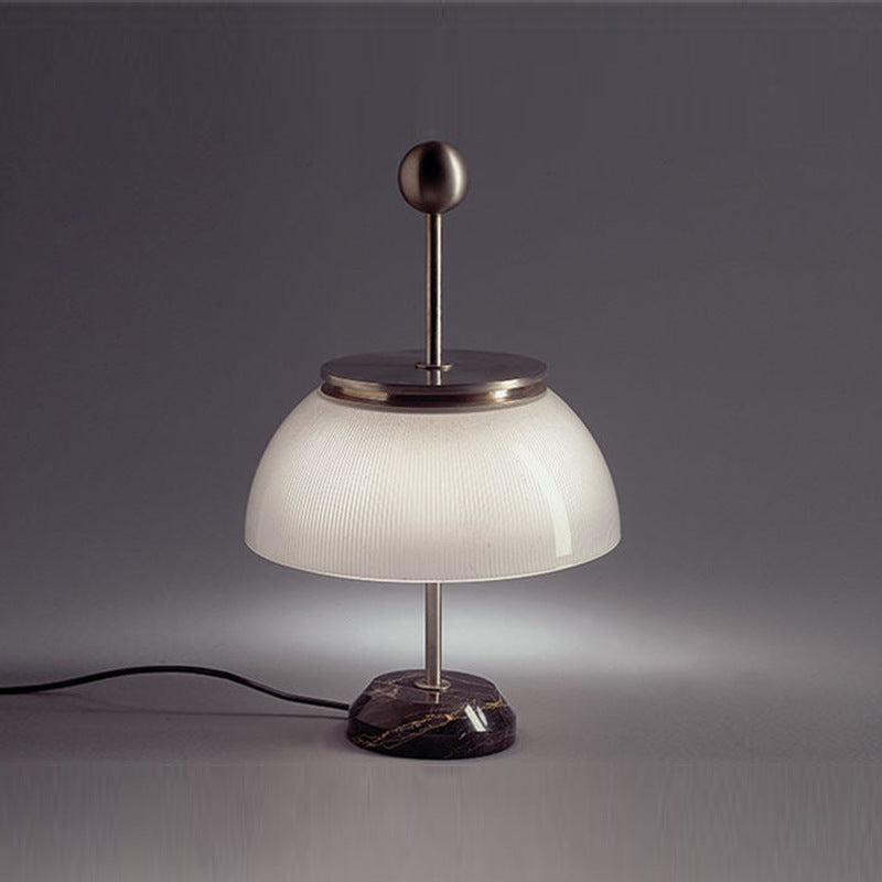 Designer ribbed glass dome lamp with marble base in dark interior