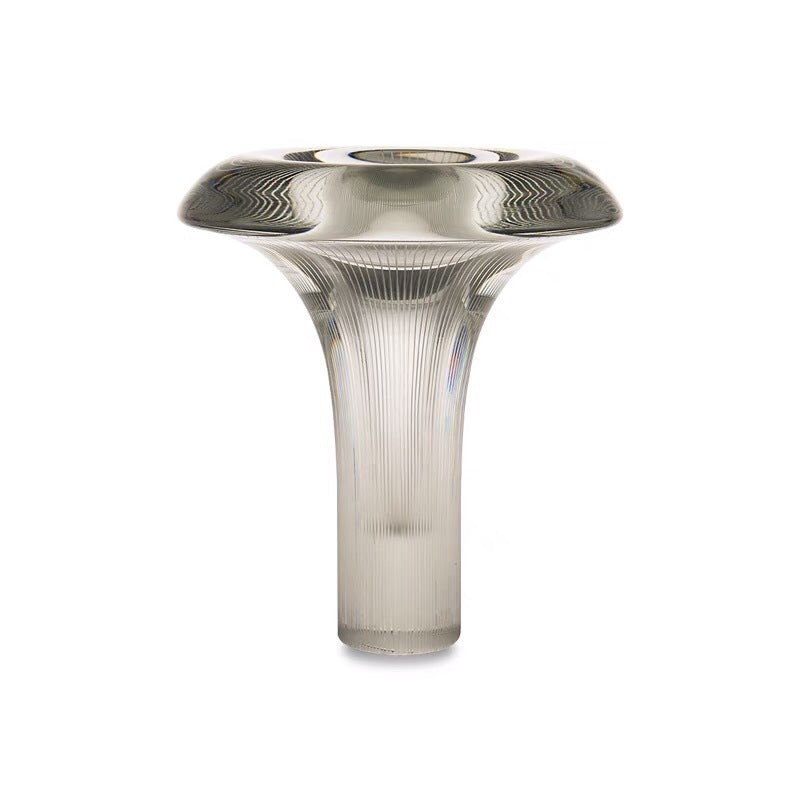 Ribbed glass sculptural table lamp glowing in bedroom