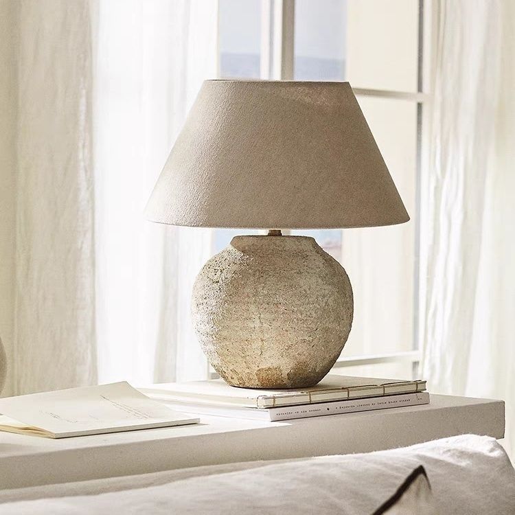 Wabi-sabi round ceramic bedside lamp beside bright window