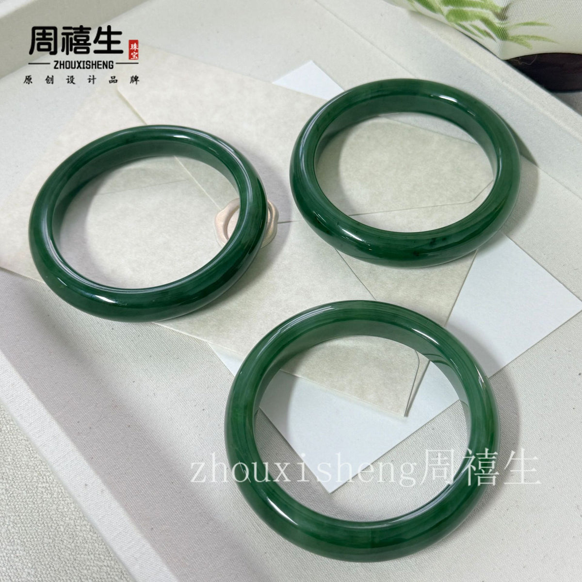 Polished spinach green Hetian jade bangles arranged on white display