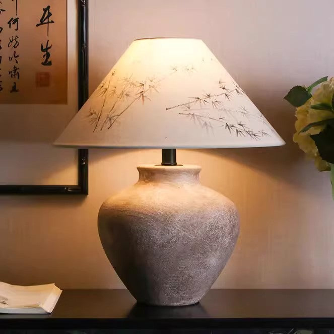 Rustic ceramic lamp with bamboo painted shade in warm ambient light