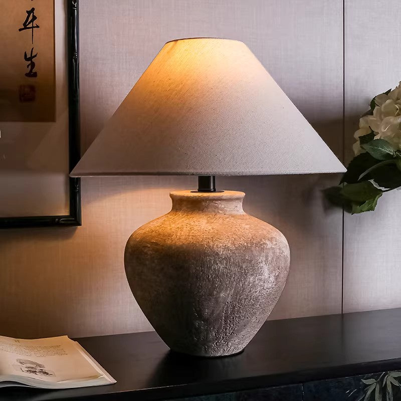 Aged brown ceramic jar lamp glowing in a New Chinese study