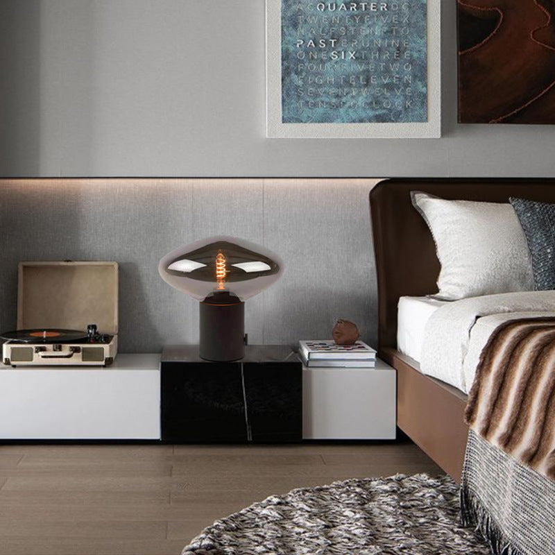 Sculptural smoked glass lamp beside a record player