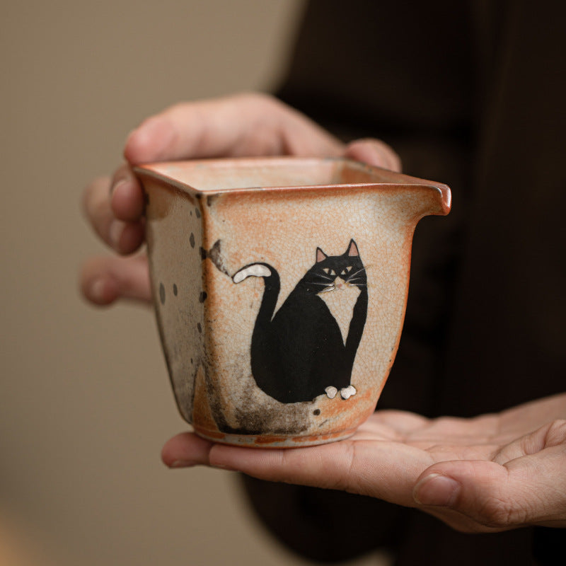 Hand-held Shino-style black cat ceramic tea pitcher showing compact 160ml size