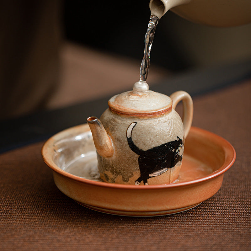 Shino black cat ceramic teapot rest shown under Gongfu teapot