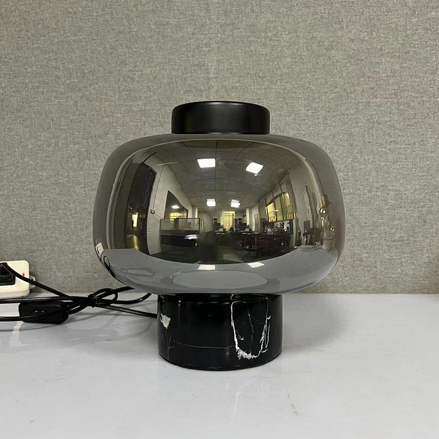 Smoke grey glass globe lamp with black marble base front view