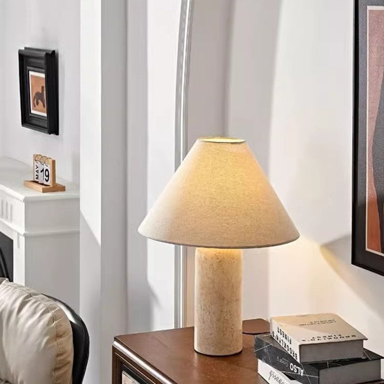 Travertine column table lamp with conical linen shade in modern living room