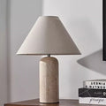 Travertine cylinder table lamp with beige tapered linen shade front view