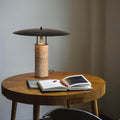 Travertine column table lamp with black floating disc shade on dining table
