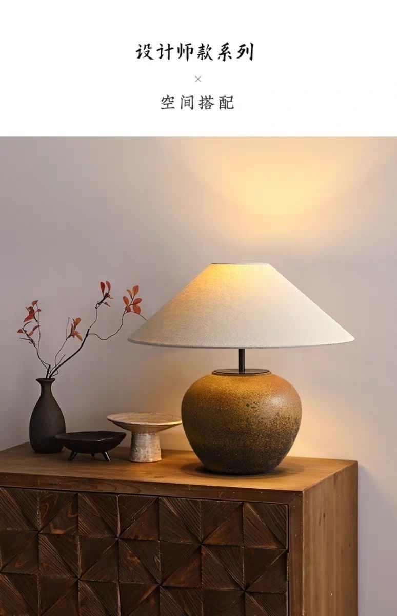 Aged brown wabi-sabi ceramic table lamp on carved wood cabinet