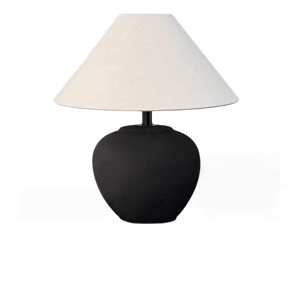 Vintage brown ceramic table lamp glowing in a warm neutral room
