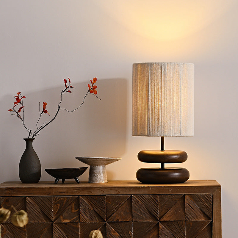 Walnut stacked wood lamp on a console in a wabi sabi interior