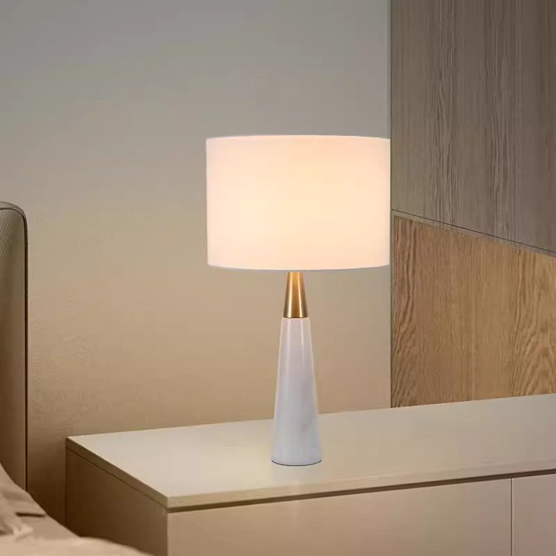 Tall white tapered marble table lamp with brass neck and white drum shade