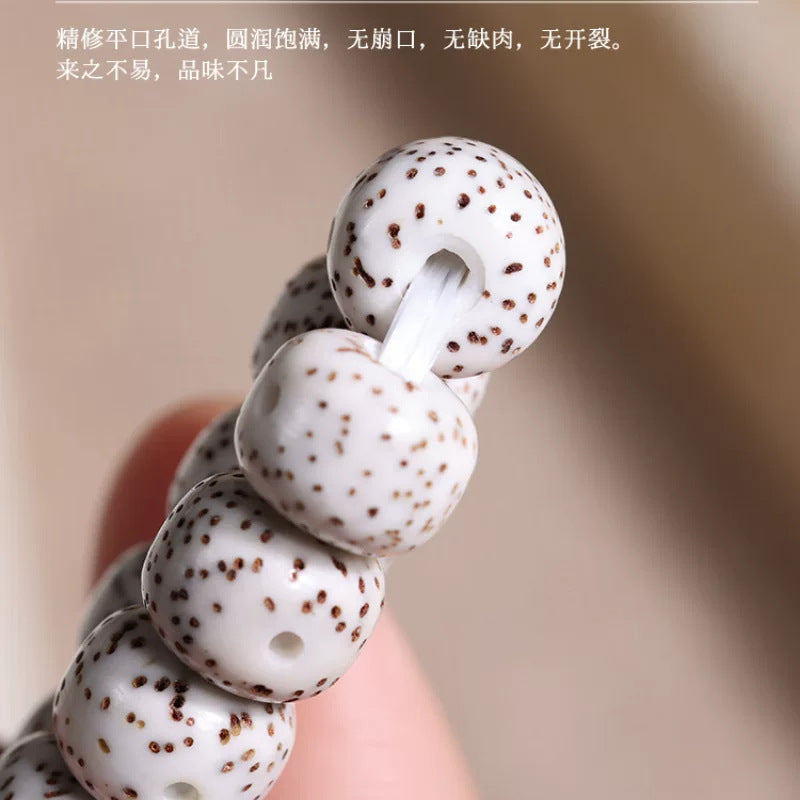 Close-up of polished white Xingyue Bodhi seed beads and drilled cord holes