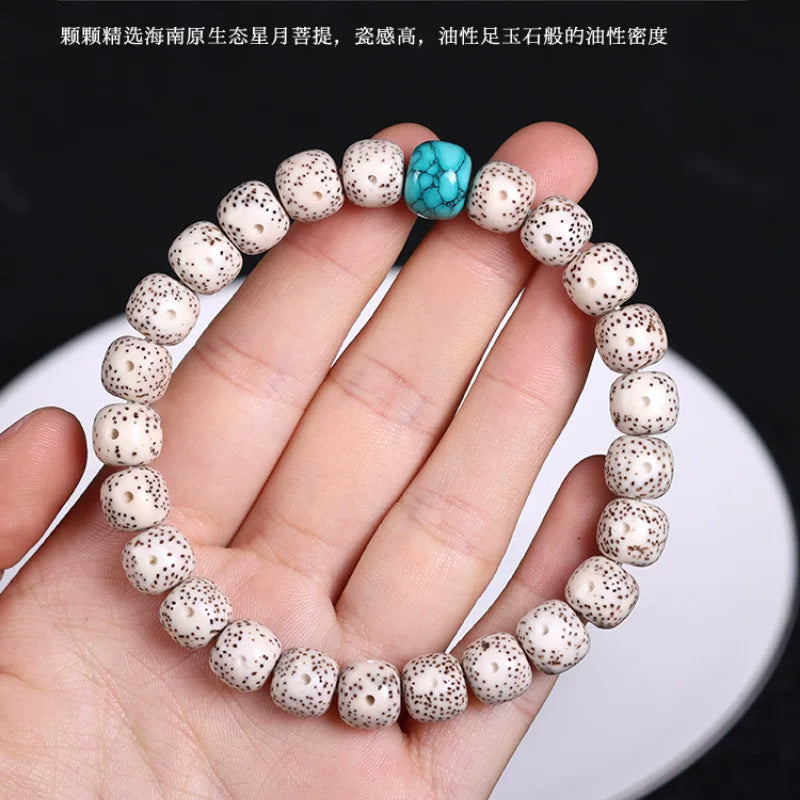 White Xingyue Bodhi bracelet shown in hand for scale