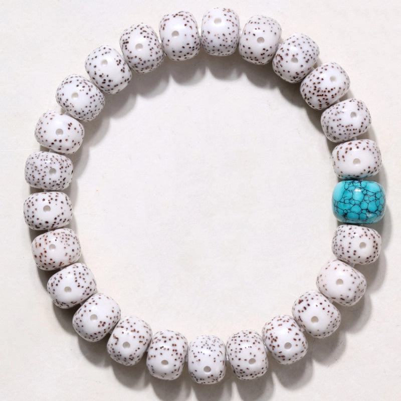 Top view showing white Xingyue Bodhi bead pattern and matrix turquoise-tone focal bead