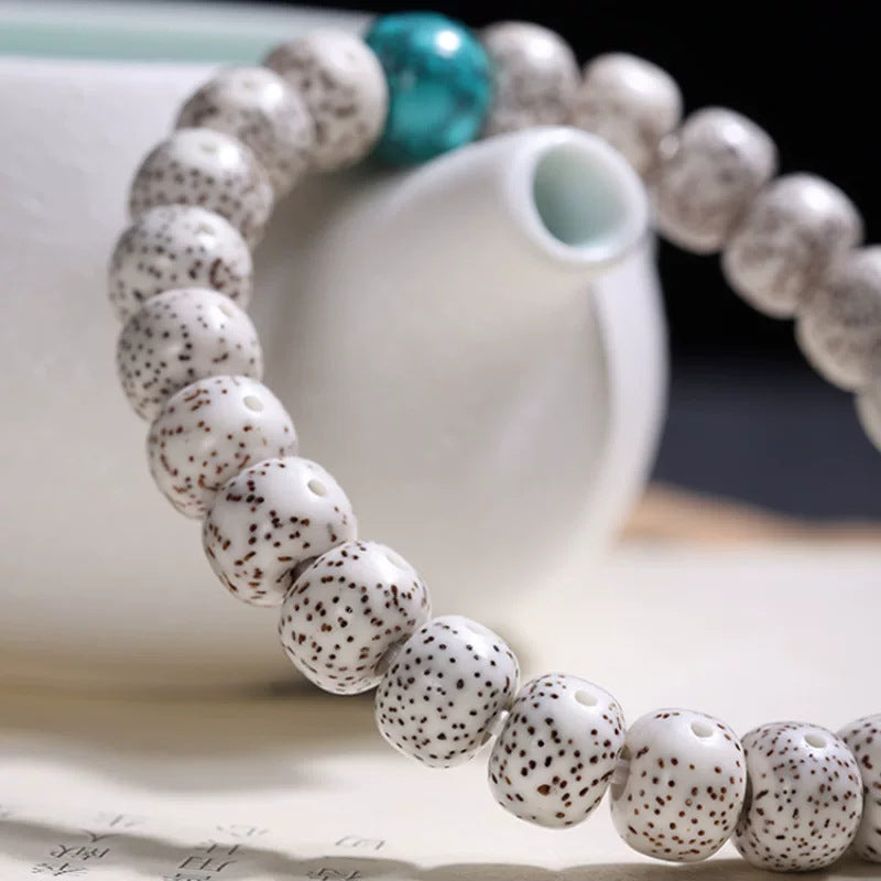 White Xingyue Bodhi bracelet styled beside ceramic teaware for tea-room display