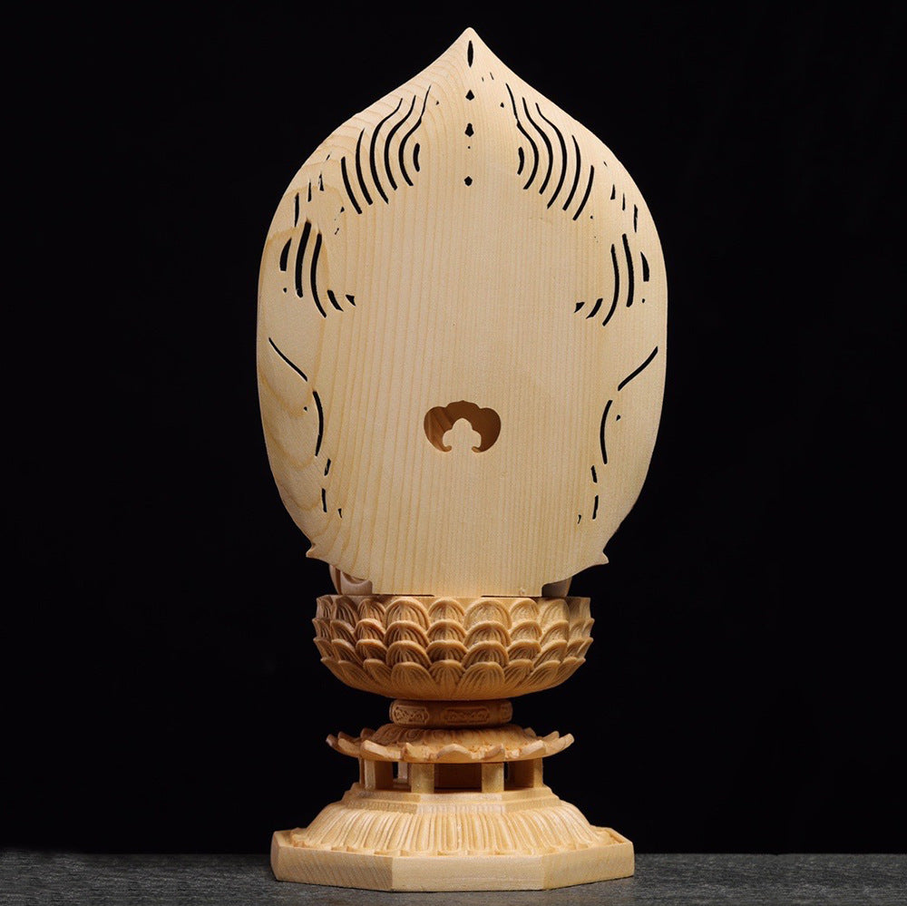 Side view of wood carved Buddha statue and openwork mandorla