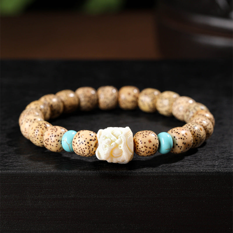 Golden Xingyue Bodhi seed bracelet with carved ivory-tone lotus centerpiece and turquoise-tone spacers