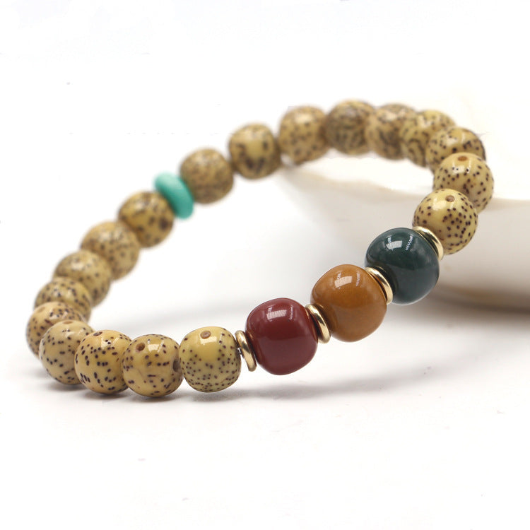 Golden Xingyue Bodhi seed bracelet with red, amber-tone and dark green accent beads