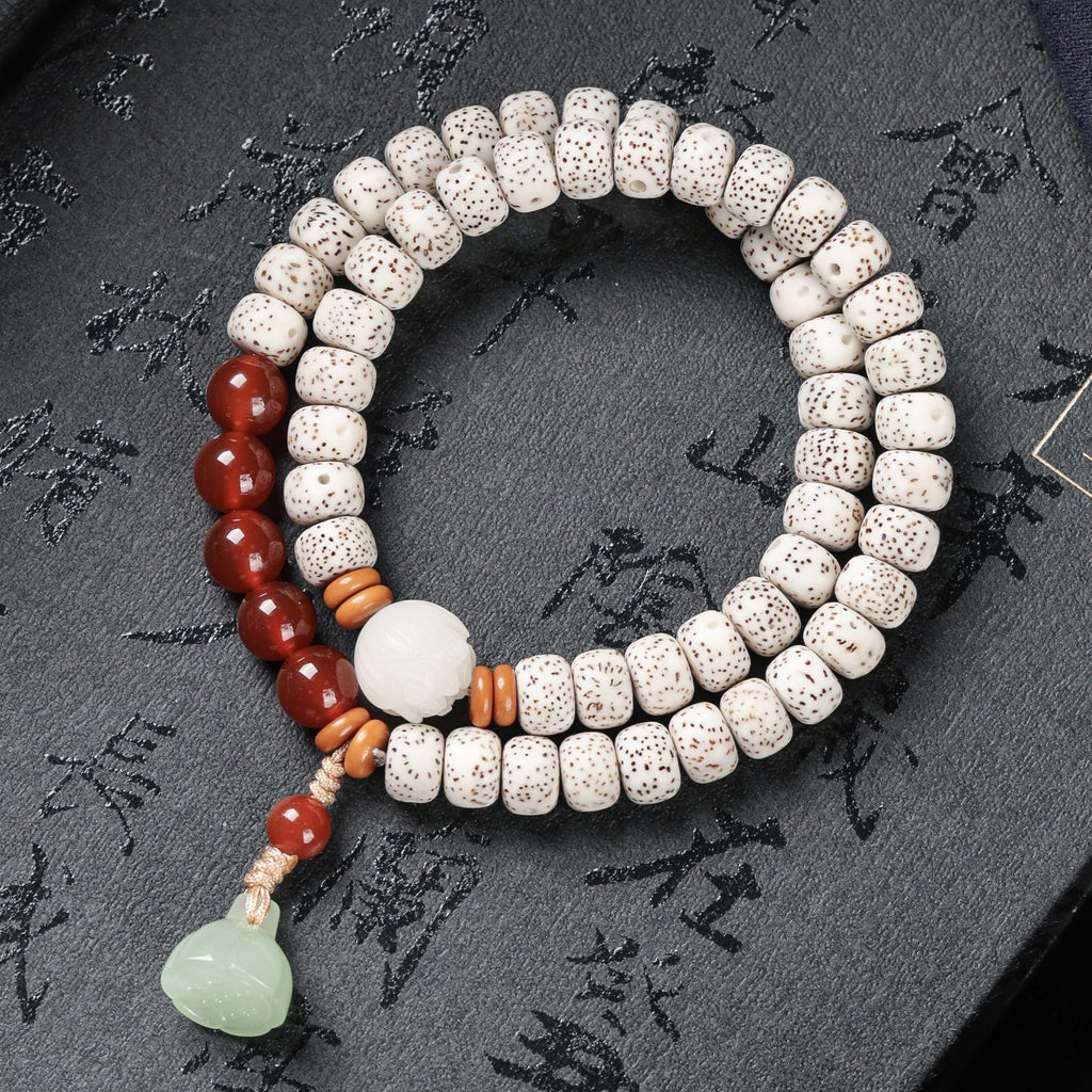 White Xingyue Bodhi double-wrap bracelet with red beads, carved lotus centerpiece and pale green pendant