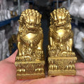 Yellow brass Chinese palace guardian lion pair with cub and ball motifs on ornate lotus-style bases, traditional entrance decor