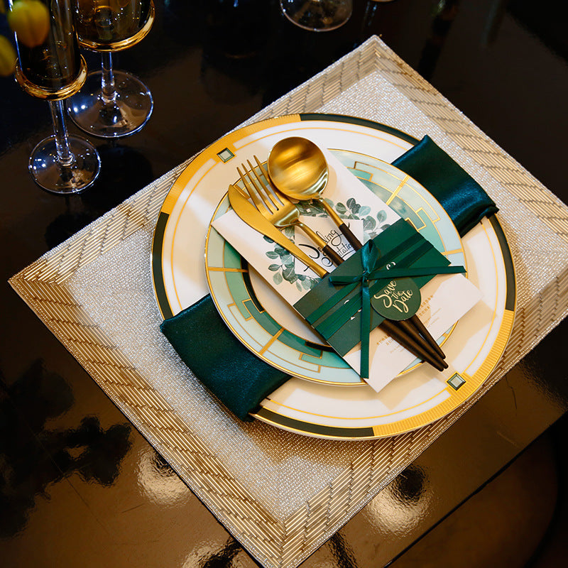 Emerald green, ivory and gold geometric luxury table setting with layered plates and flatware