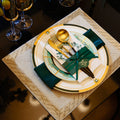 Emerald green, ivory and gold geometric luxury table setting with layered plates and flatware