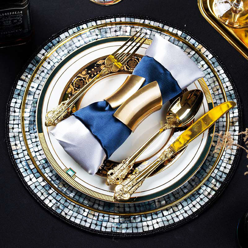 Luxury emerald green and gold place setting with round decorative placemat and layered dinnerware