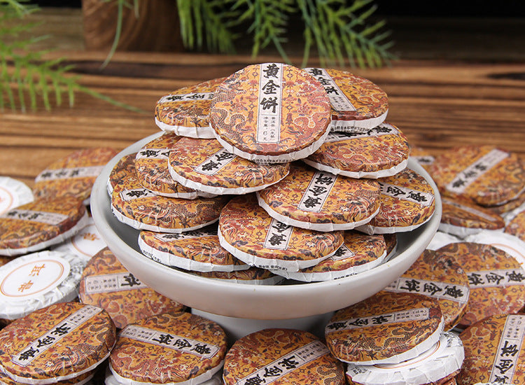 Ancient tree Golden Leaf raw Pu-erh mini cakes displayed for tea service