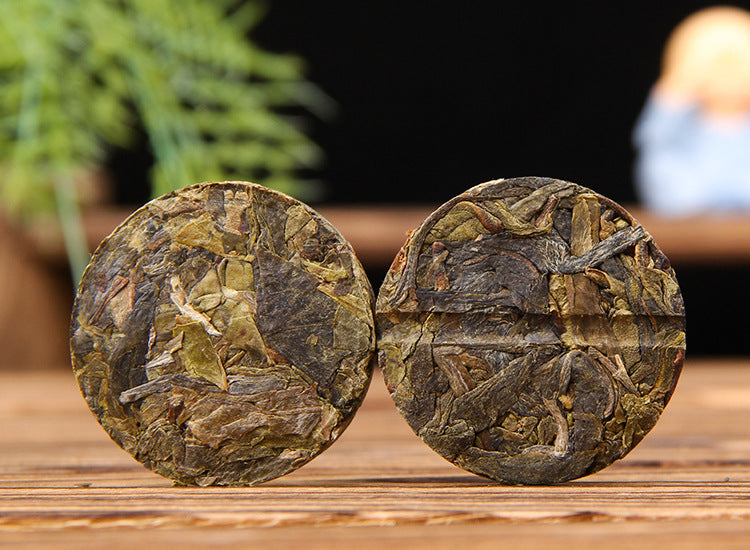 Golden Leaf raw Pu-erh mini cake showing compressed large-leaf tea material