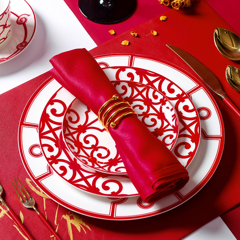 Grande red geometric layered place setting with red napkin and gold-tone flatware