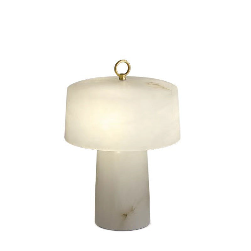 Sculptural white faux marble resin lamp with brass ring finial and warm glow