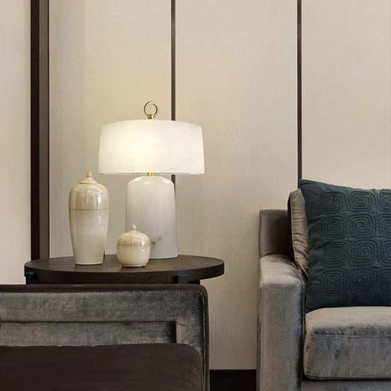 Faux alabaster resin table lamp styled on a side table beside a sofa
