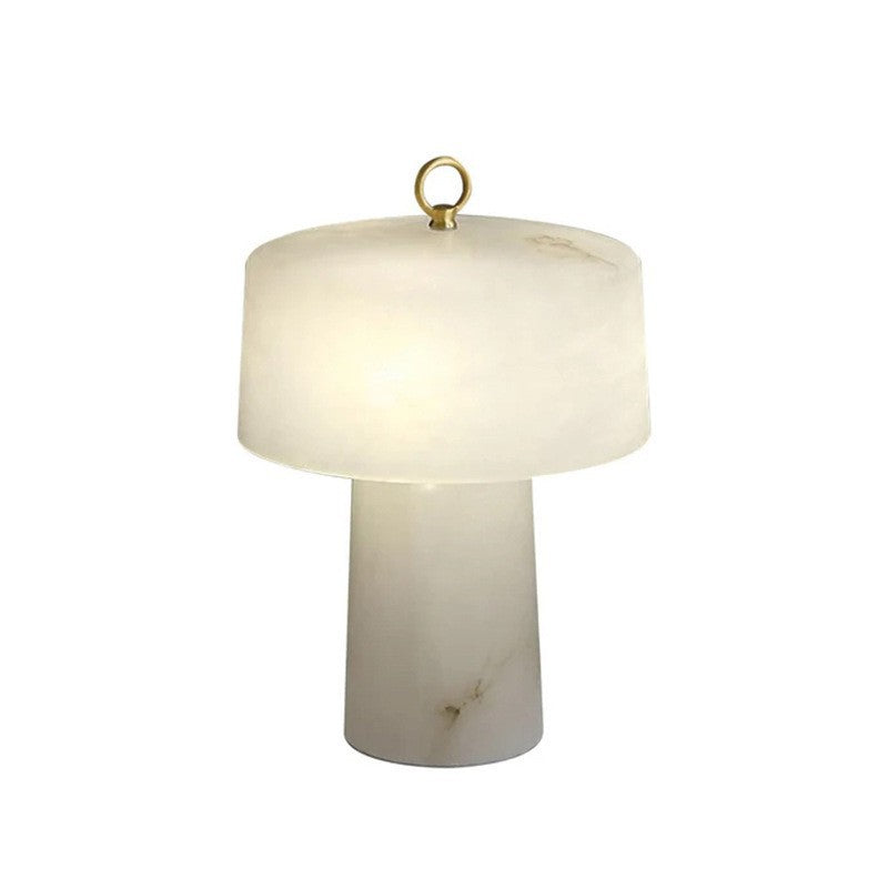 White faux alabaster resin table lamp with bell-shaped glowing shade and tapered column base