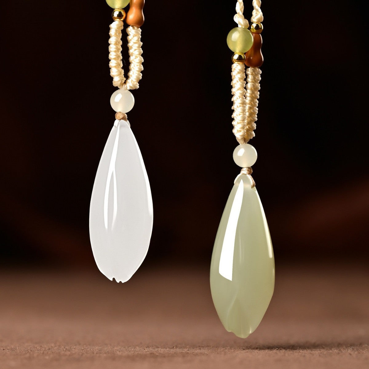 Qing Shui green and white Hetian jade magnolia pendants side by side