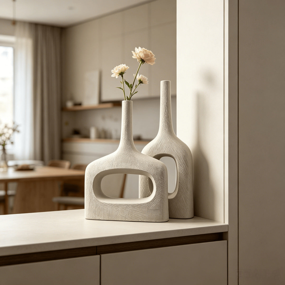 White hollow geometric ceramic vases styled on a contemporary console