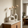 White hollow geometric ceramic vases styled with flowers in a warm minimalist interior