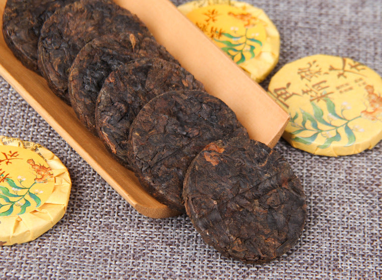 Huangjing ripe Pu-erh mini compressed tea cakes displayed on a wooden tray
