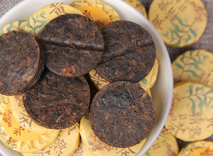 Bowl of unwrapped Huangjing ripe Pu-erh mini compressed tea cakes