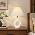 Ivory white hollow ring ceramic table lamp styled on a New Chinese wood console