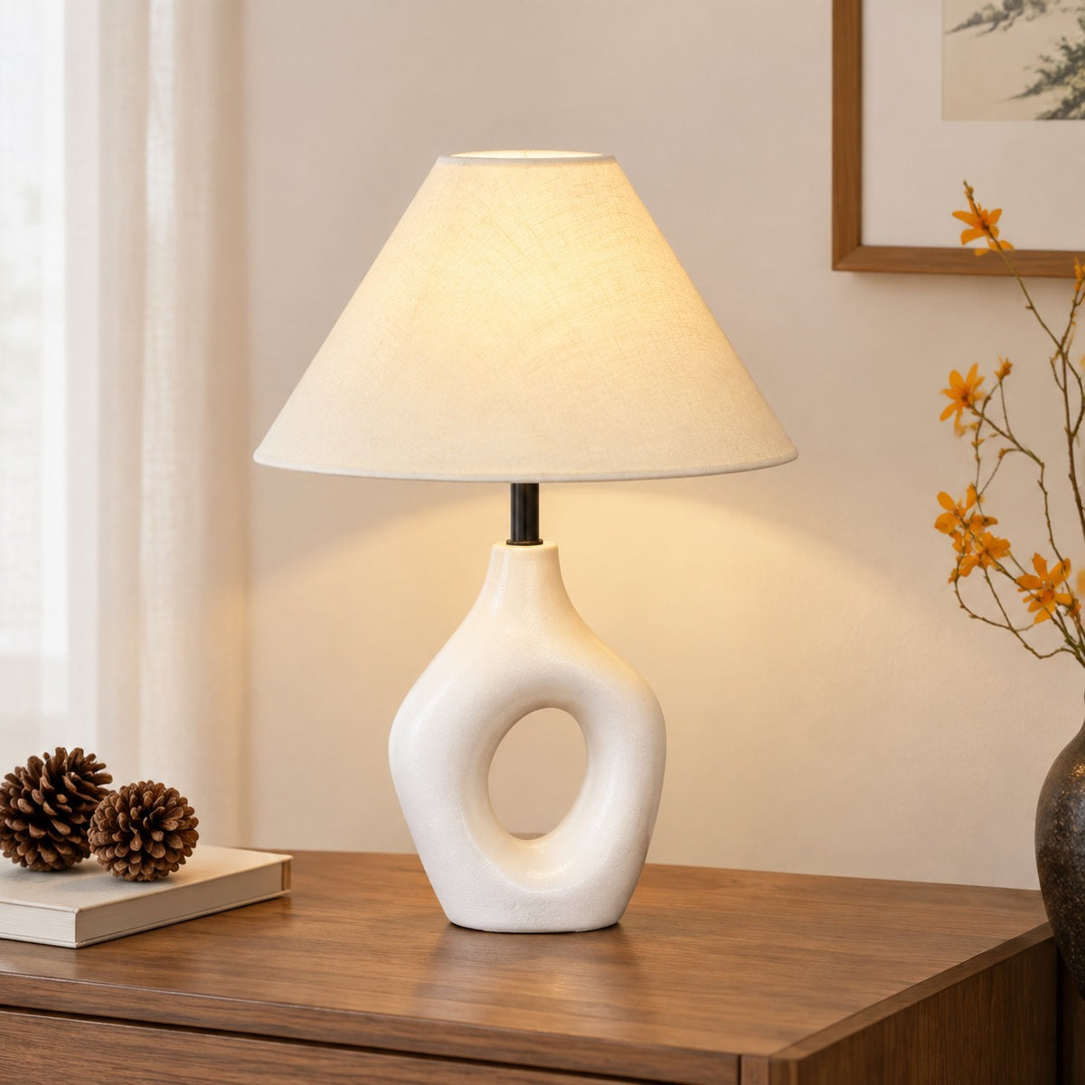 White sculptural cutout ceramic table lamp with warm fabric shade