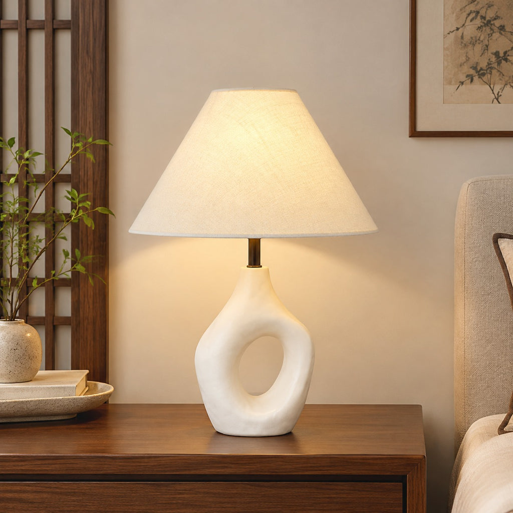 White ceramic cutout lamp paired with walnut furniture and neutral textiles