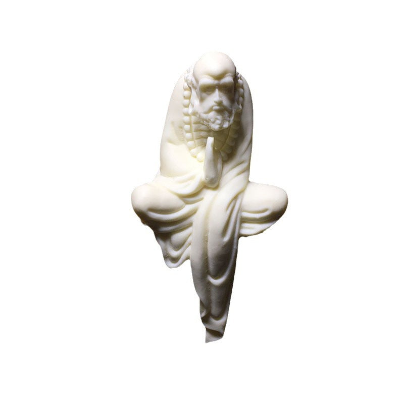 Natural vegetable ivory Bodhidharma seated sculpture isolated on white background for shelf or tea room display